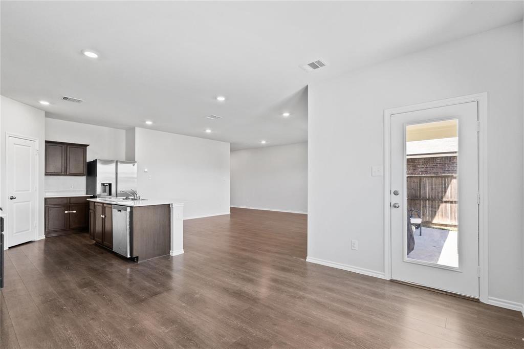 1287 Delmita Drive, Unit 1287 Forney, TX 75126 - Photo 23 of 23 Kitchen with open floor plan, dark brown cabinetry, an island with sink, dark wood-type flooring, and recessed lighting