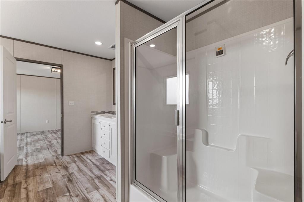 3924 Sandusky Road Whitesboro, TX 76273 - Photo 22 of 40 Full bath featuring a stall shower, crown molding, wood finished floors, and vanity