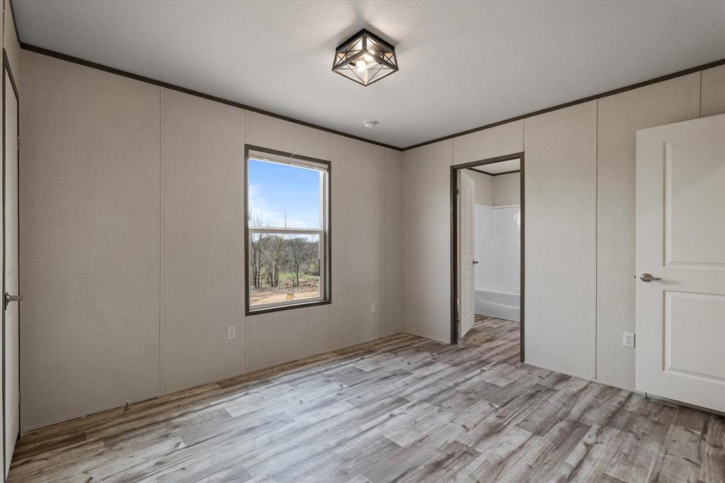 3924 Sandusky Road Whitesboro, TX 76273 - Photo 26 of 40 Unfurnished bedroom with light wood finished floors and crown molding