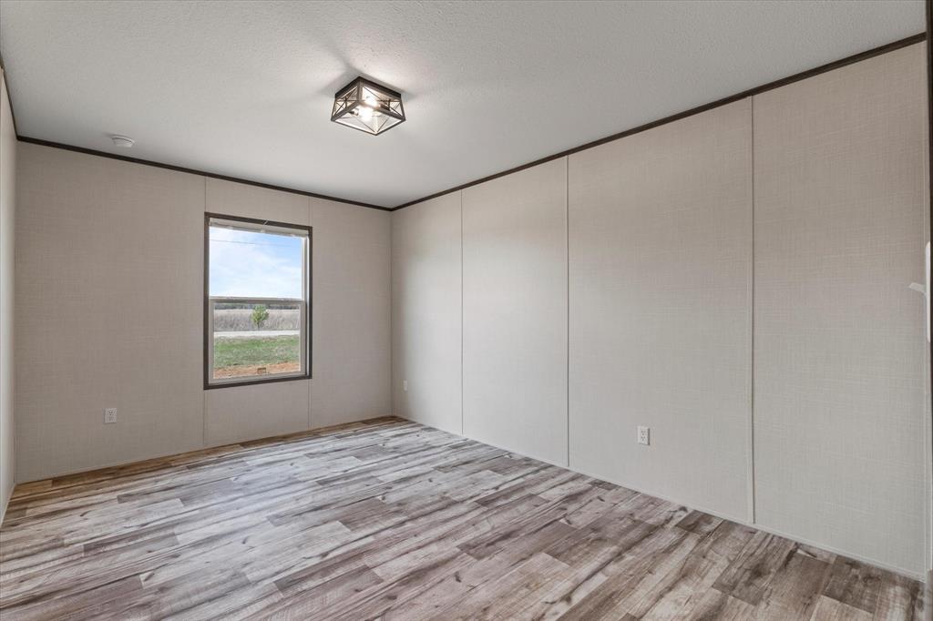 3924 Sandusky Road Whitesboro, TX 76273 - Photo 28 of 40 Spare room with light wood finished floors and crown molding