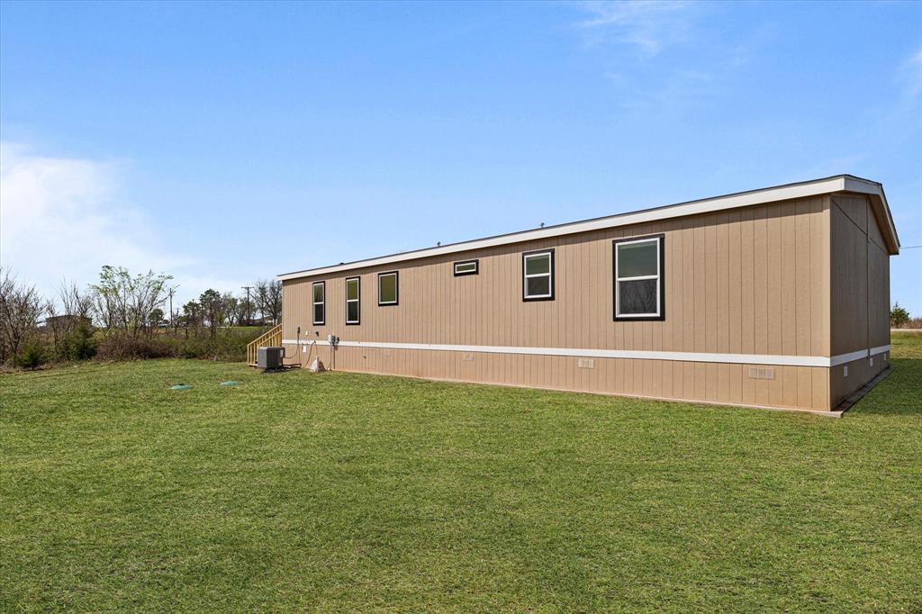 3924 Sandusky Road Whitesboro, TX 76273 - Photo 35 of 40 View of home's exterior with central AC unit and a yard