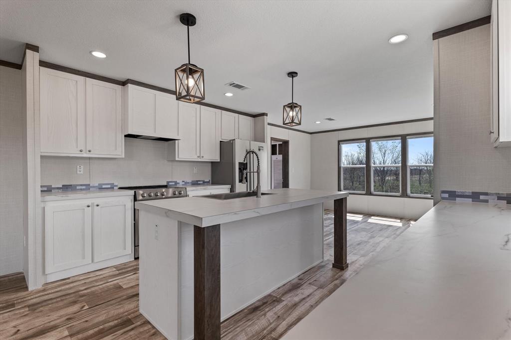 3924 Sandusky Road Whitesboro, TX 76273 - Photo 9 of 40 Kitchen featuring visible vents, light countertops, light wood-style flooring, and stainless steel appliances