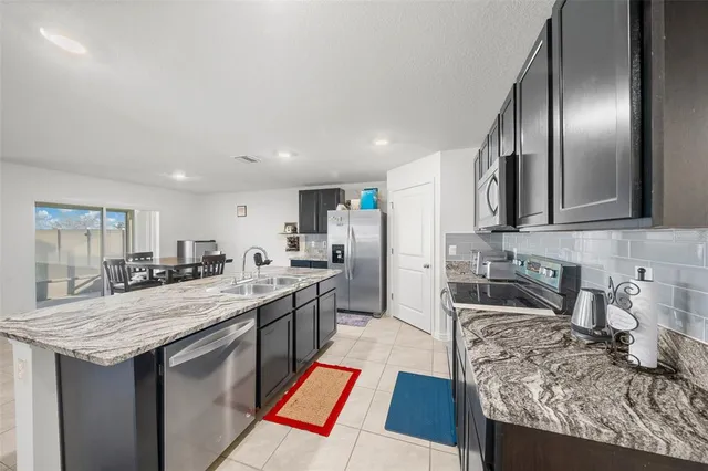 a kitchen with granite countertop stainless steel appliances and sink