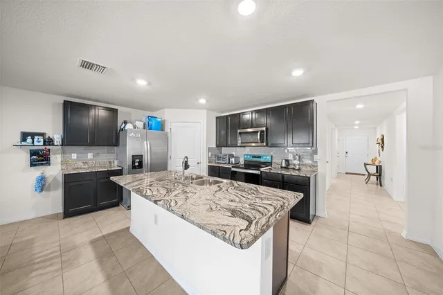 a large kitchen with a stove top oven and refrigerator