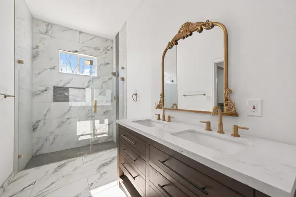 a bathroom with a double vanity sink mirror and shower