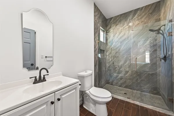 a bathroom with a sink a toilet and a mirror