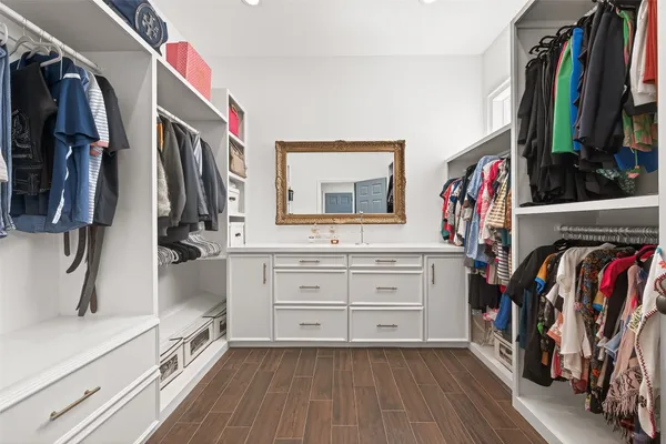 a view of walk in closet with clothes and shoes