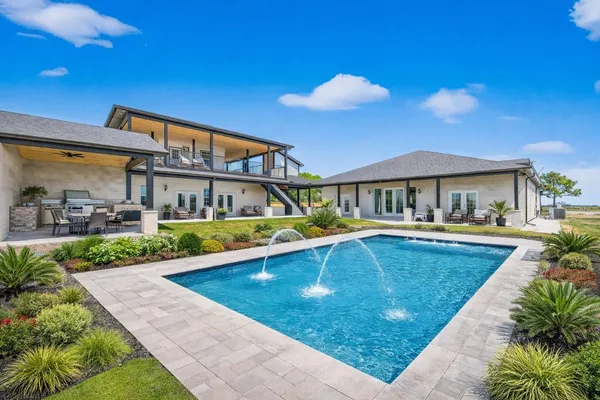 a house view with swimming pool in front of it