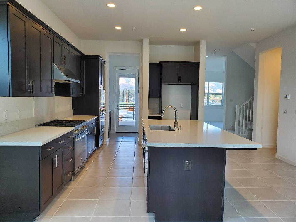 Pastoral Loop San Jose, CA 95122 - Photo 7 of 14 a large kitchen with kitchen island a sink a counter top and stainless steel appliances