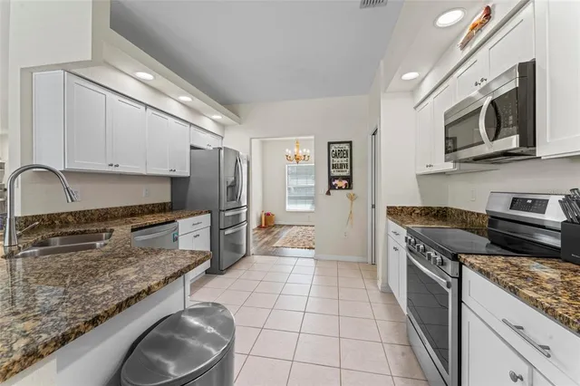 a kitchen with stainless steel appliances granite countertop a stove a sink and a microwave