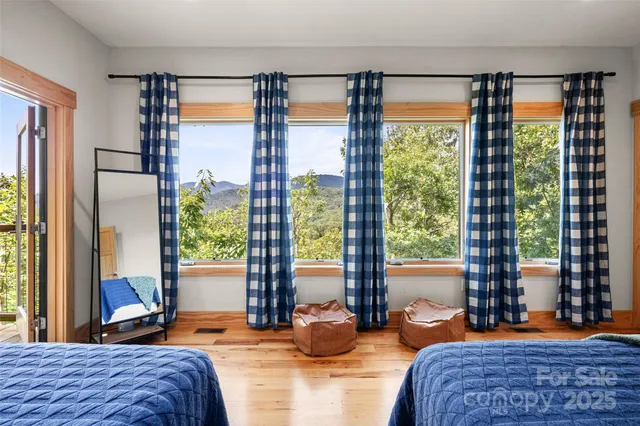 a bedroom with a large bed and large windows