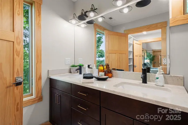 a bathroom with a sink a large mirror and vanity