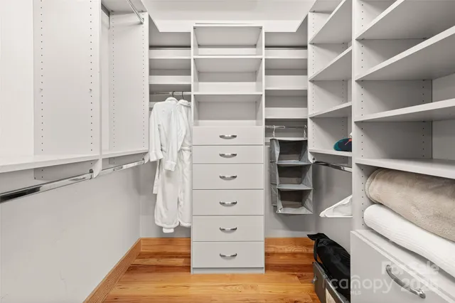 a view of walk in closet with empty racks