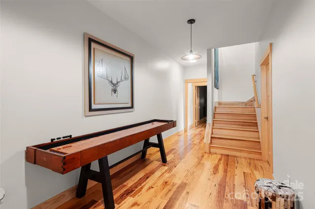 a hallway with a bench and a chandelier
