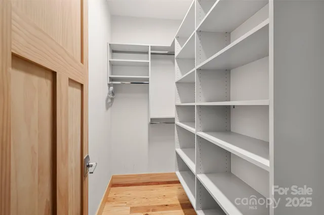 a view of walk in closet with empty racks