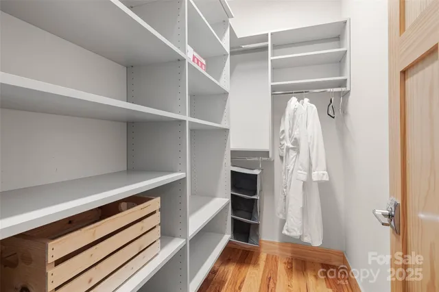 a view of walk in closet with clothes and shoes