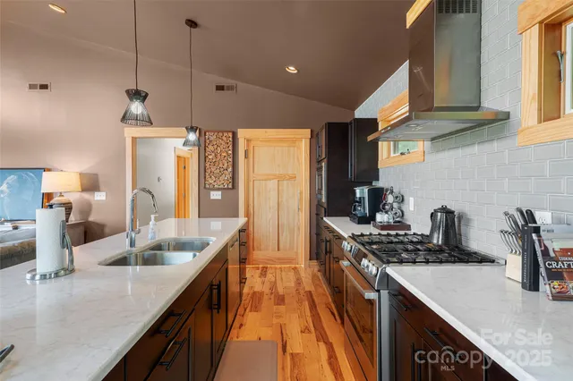a kitchen with granite countertop a sink a counter space appliances and cabinets