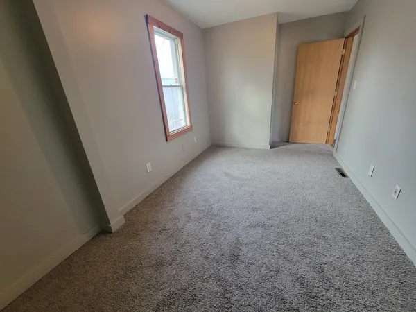 an empty room with windows and closet