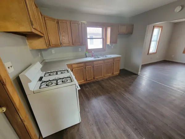 a kitchen with granite countertop a stove a sink and a refrigerator