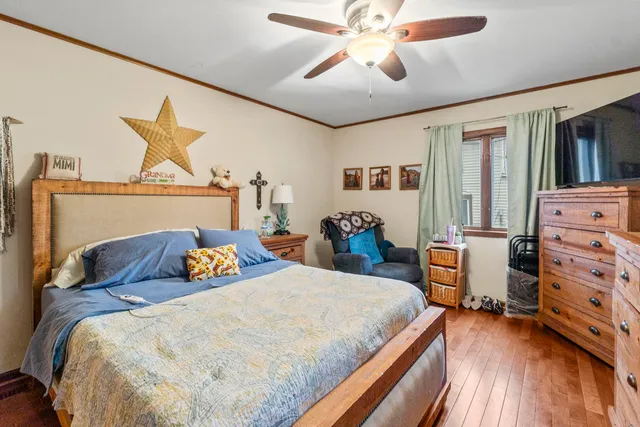 a bedroom with a bed and wooden floor