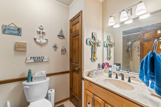 a bathroom with a granite countertop toilet sink and mirror