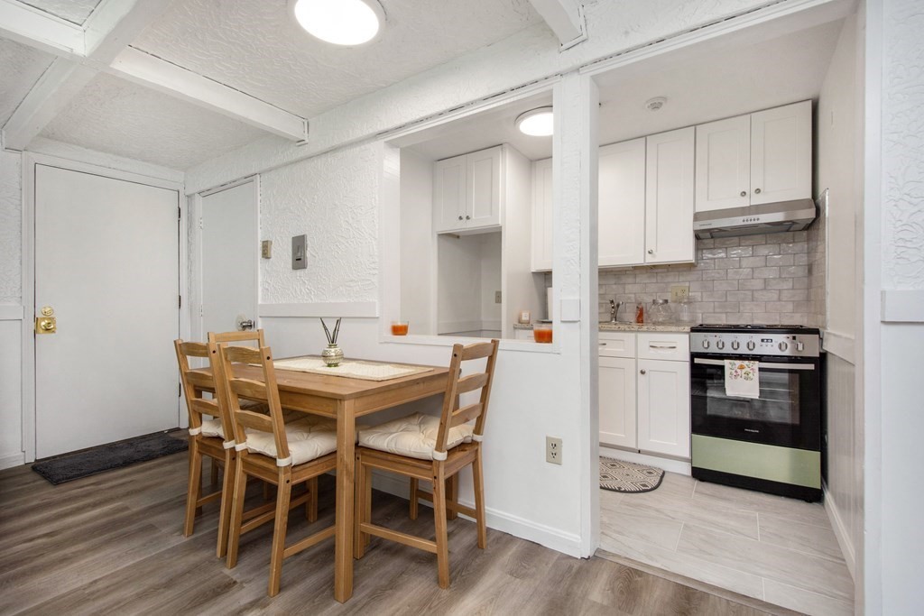 41 Spencer Road, Unit G16 Boxborough, MA 01719 - Photo 7 of 17 a kitchen with stainless steel appliances a white table chairs and a refrigerator