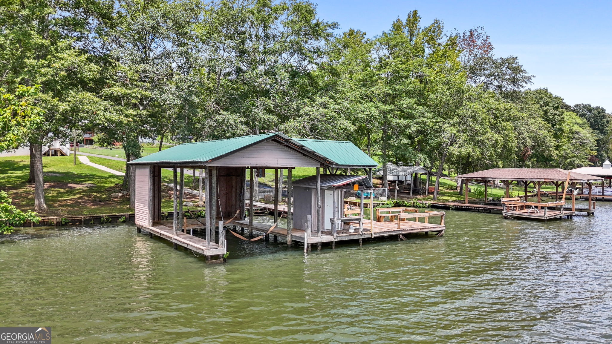 868 South Steel Bridge Road Eatonton, GA 31024 - Photo 13 of 64 a view of a lake with boats and trees in the background