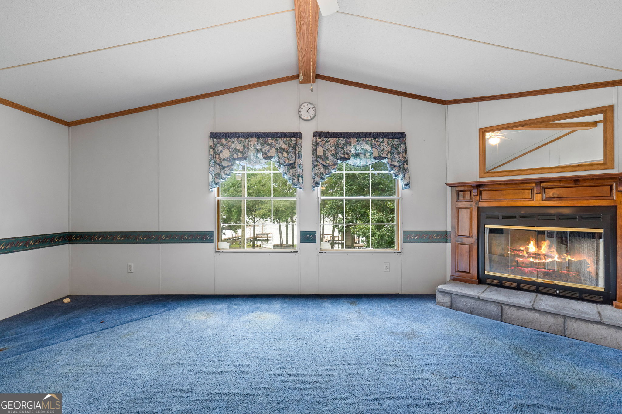 868 South Steel Bridge Road Eatonton, GA 31024 - Photo 33 of 64 an empty room with wooden floor fireplace and windows
