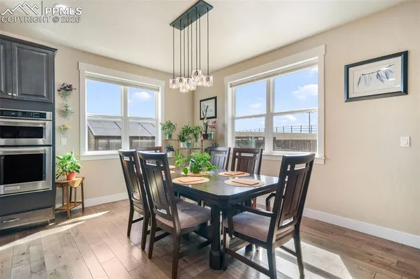 a kitchen with stainless steel appliances granite countertop a dining table chairs and stove top oven