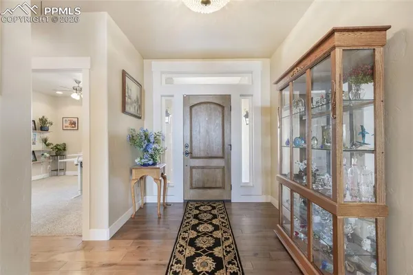 a kitchen with stainless steel appliances granite countertop a stove top oven a sink dishwasher a dining table and chairs with wooden floor