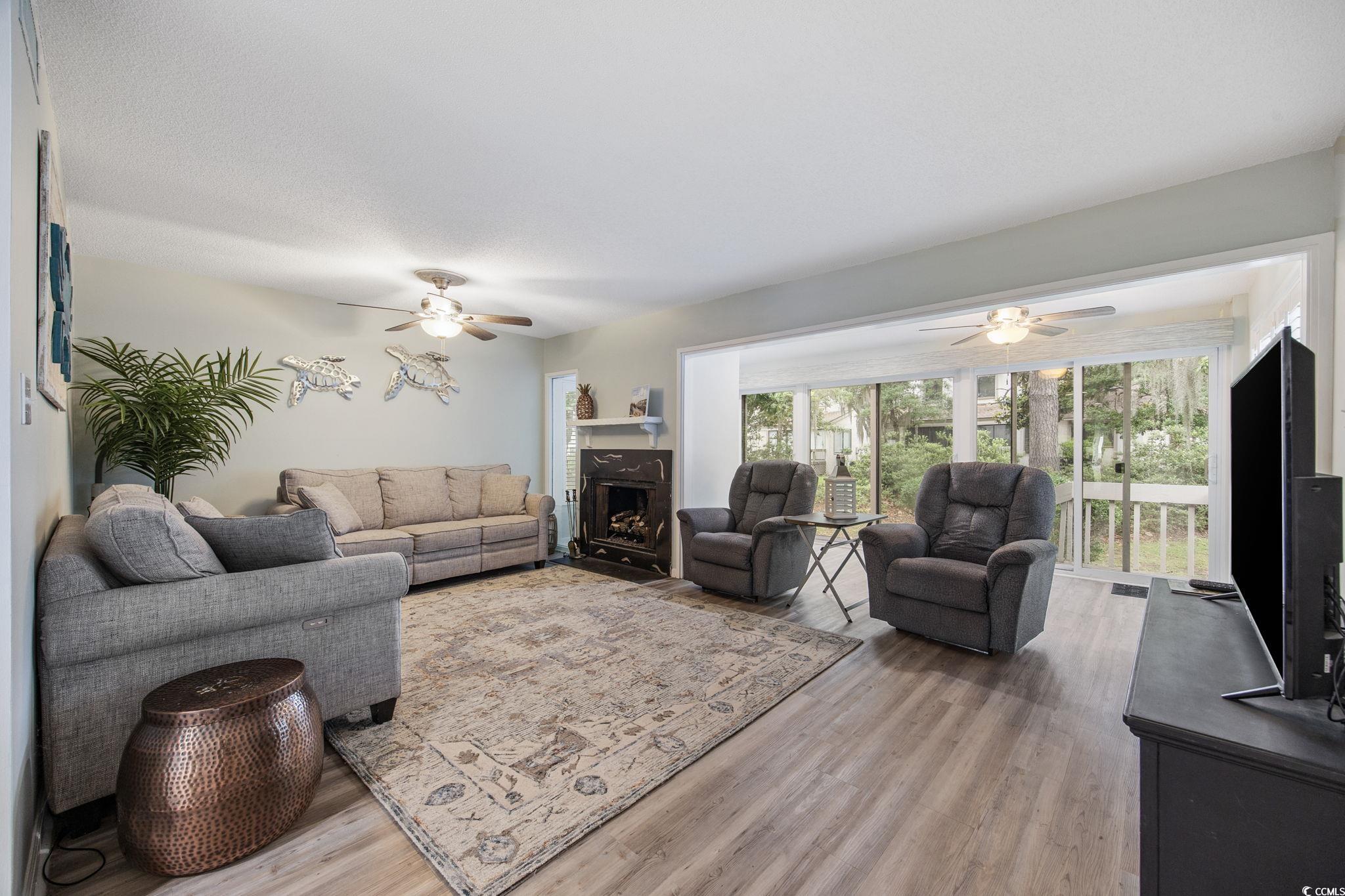 64 Bamboo Loop, Unit 161 Georgetown, SC 29440 - Photo 19 of 31 Living area featuring a ceiling fan, light wood-type flooring, and a fireplace