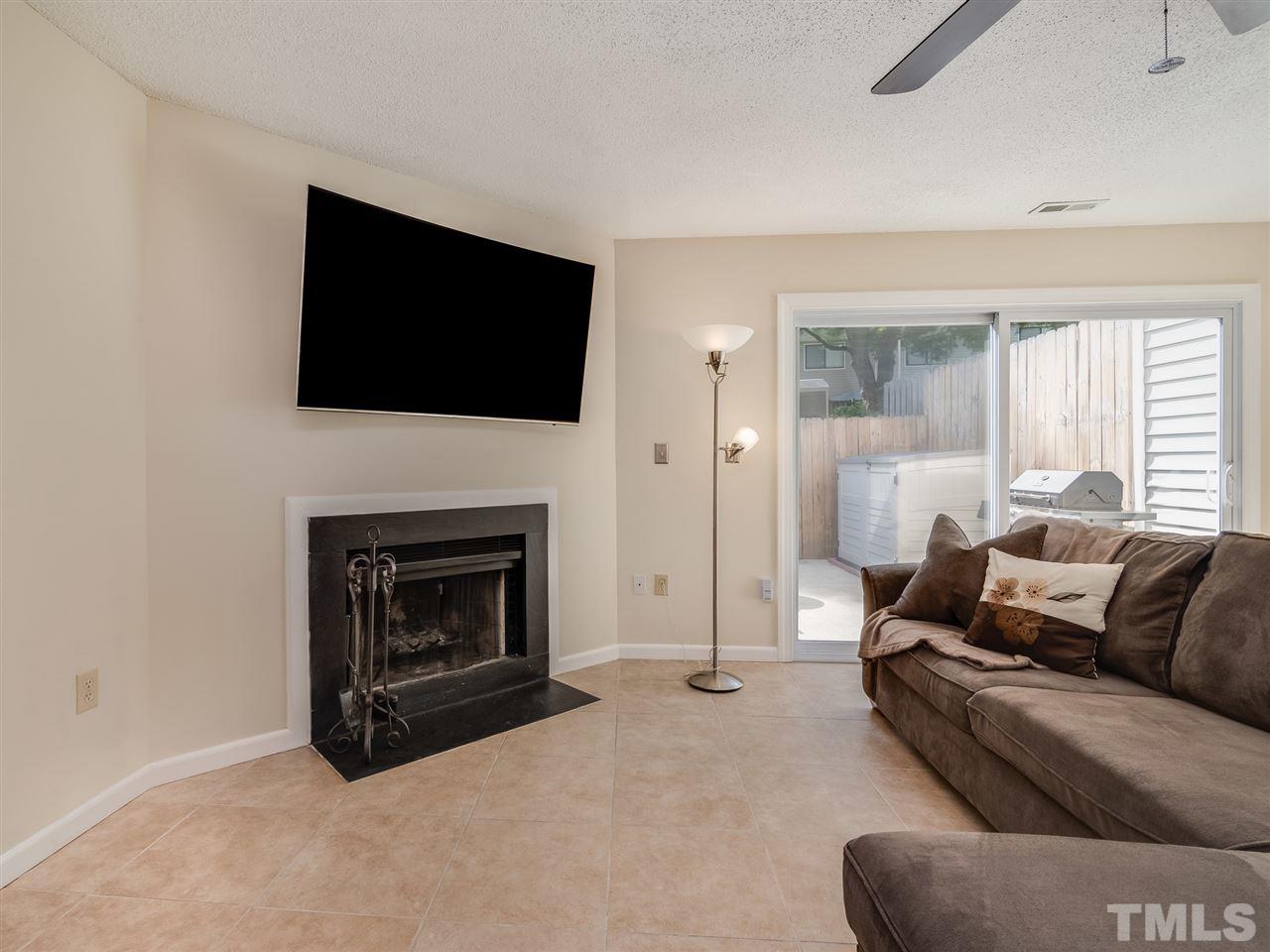 5932 Shady Grove Circle Raleigh, NC 27609 - Photo 13 of 28 a living room with furniture a flat screen tv and a fireplace