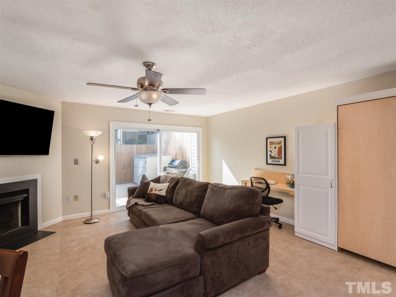 5932 Shady Grove Circle Raleigh, NC 27609 - Photo 16 of 28 a living room with furniture a fireplace and a flat screen tv