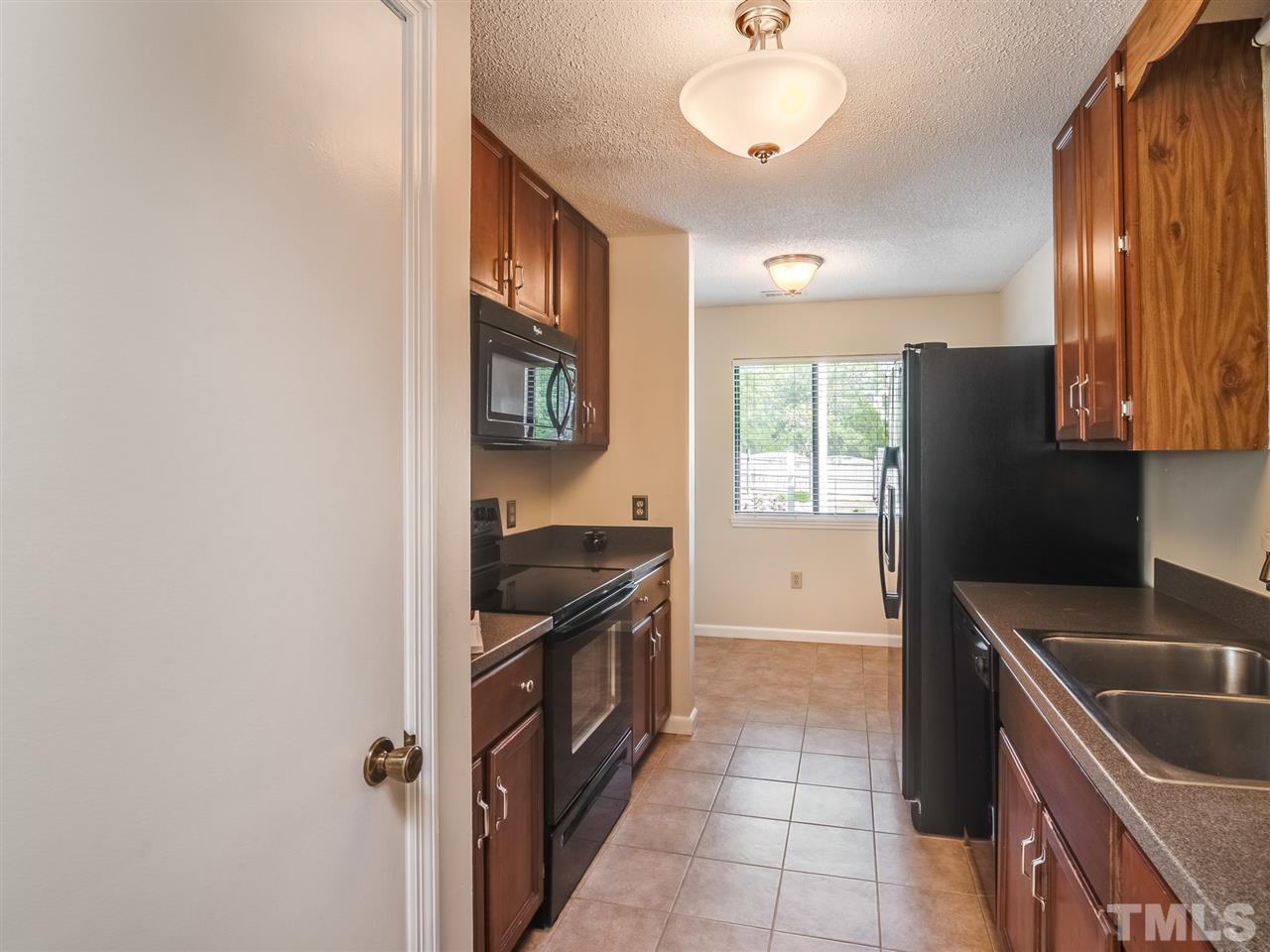 5932 Shady Grove Circle Raleigh, NC 27609 - Photo 4 of 28 a kitchen with granite countertop a stove and a refrigerator