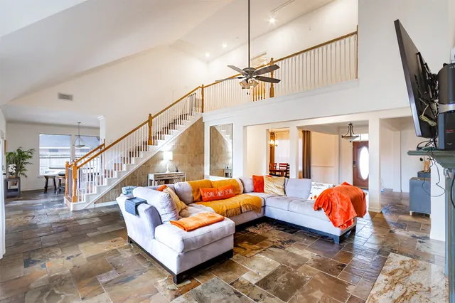 a living room with furniture a ceiling fan and a rug