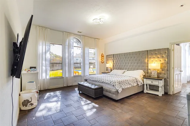 a spacious bedroom with a bed and a large window