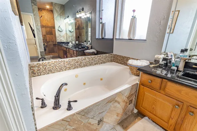a bathroom with a tub sink and mirror