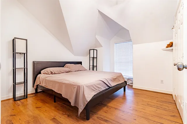 a bedroom with a bed and wooden floor