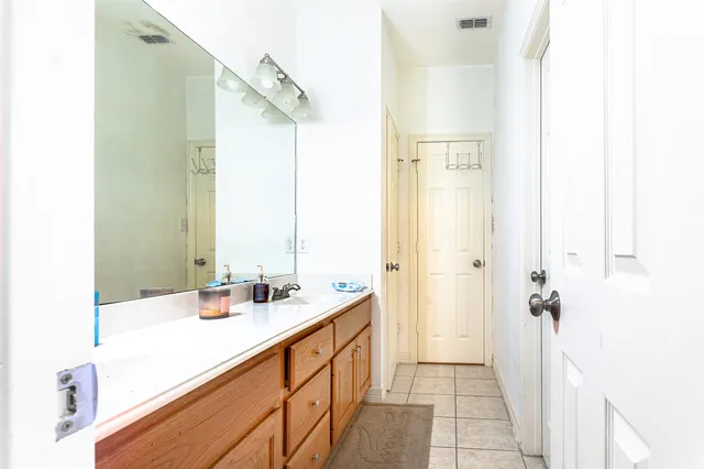 a bathroom with a double vanity sink a mirror and a bathtub