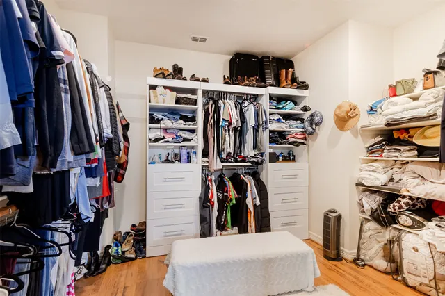 a view of walk in closet with clothes and shoes