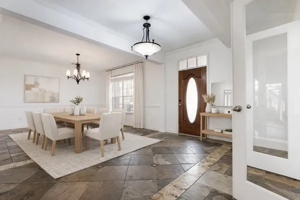 a dining room with furniture a chandelier and wooden floor