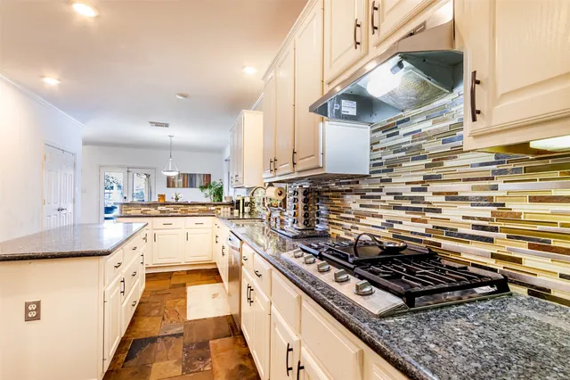 a kitchen with stainless steel appliances granite countertop a stove and a sink