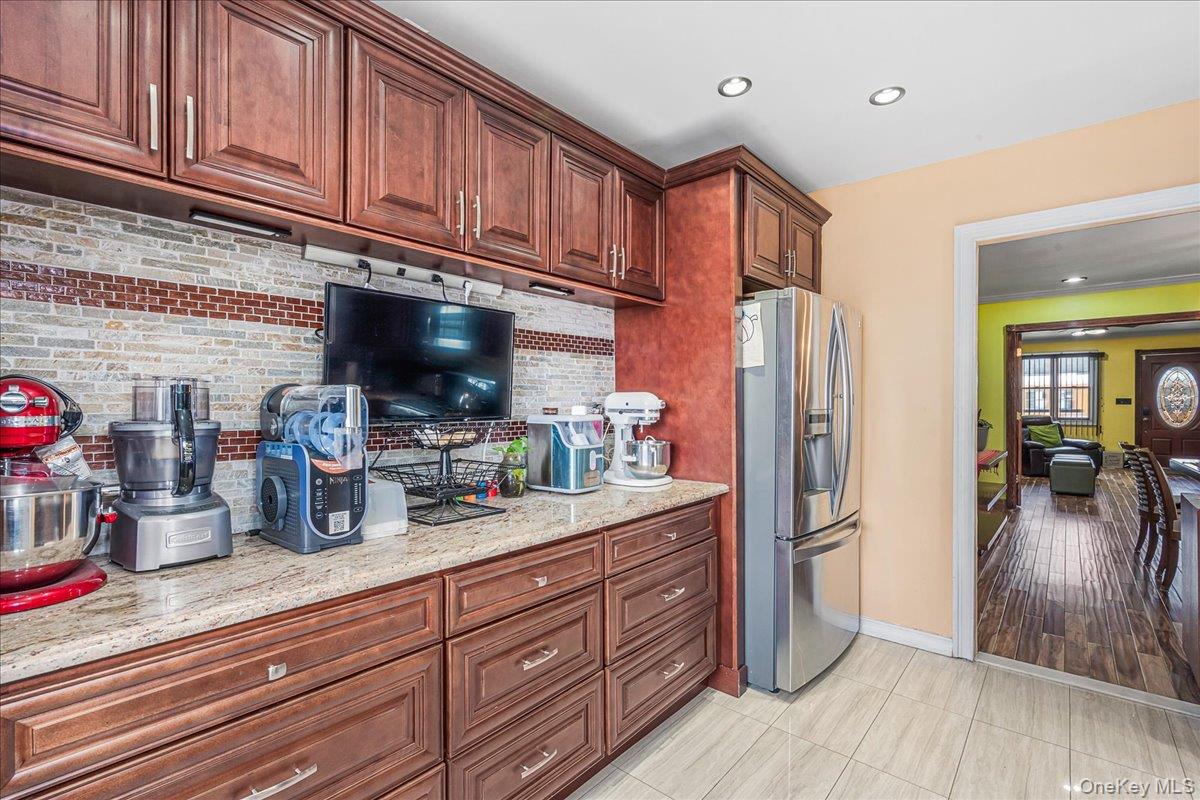 14428 158th Street Queens, NY 11434 - Photo 7 of 17 a kitchen with stainless steel appliances granite countertop a refrigerator and wooden cabinets