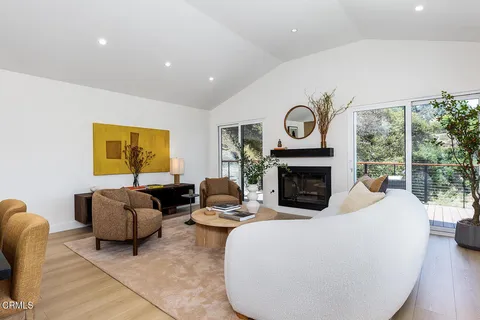 a living room with furniture a fireplace and a large window