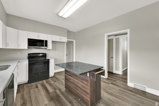 716 East Factory Street Garland, UT 84312 - Photo 17 of 30 Modern kitchen featuring white cabinetry, a built-in microwave, and a black electric range