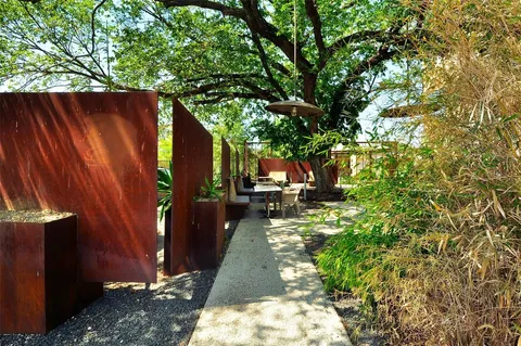 a kitchen with stainless steel appliances granite countertop a table chairs sink and cabinets