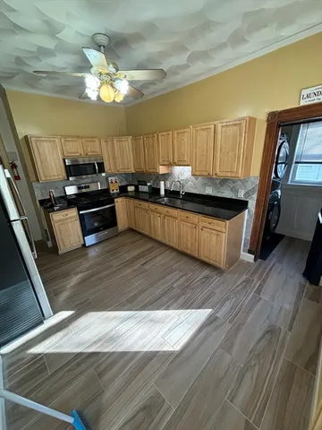 a kitchen with stainless steel appliances granite countertop a stove a sink dishwasher and a microwave oven with cabinets