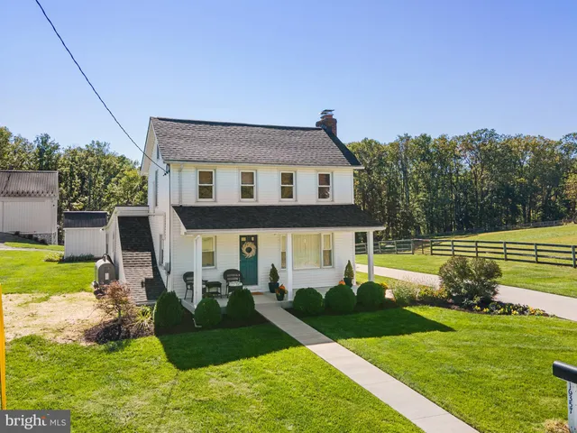 an empty room with wooden floor fireplace and windows