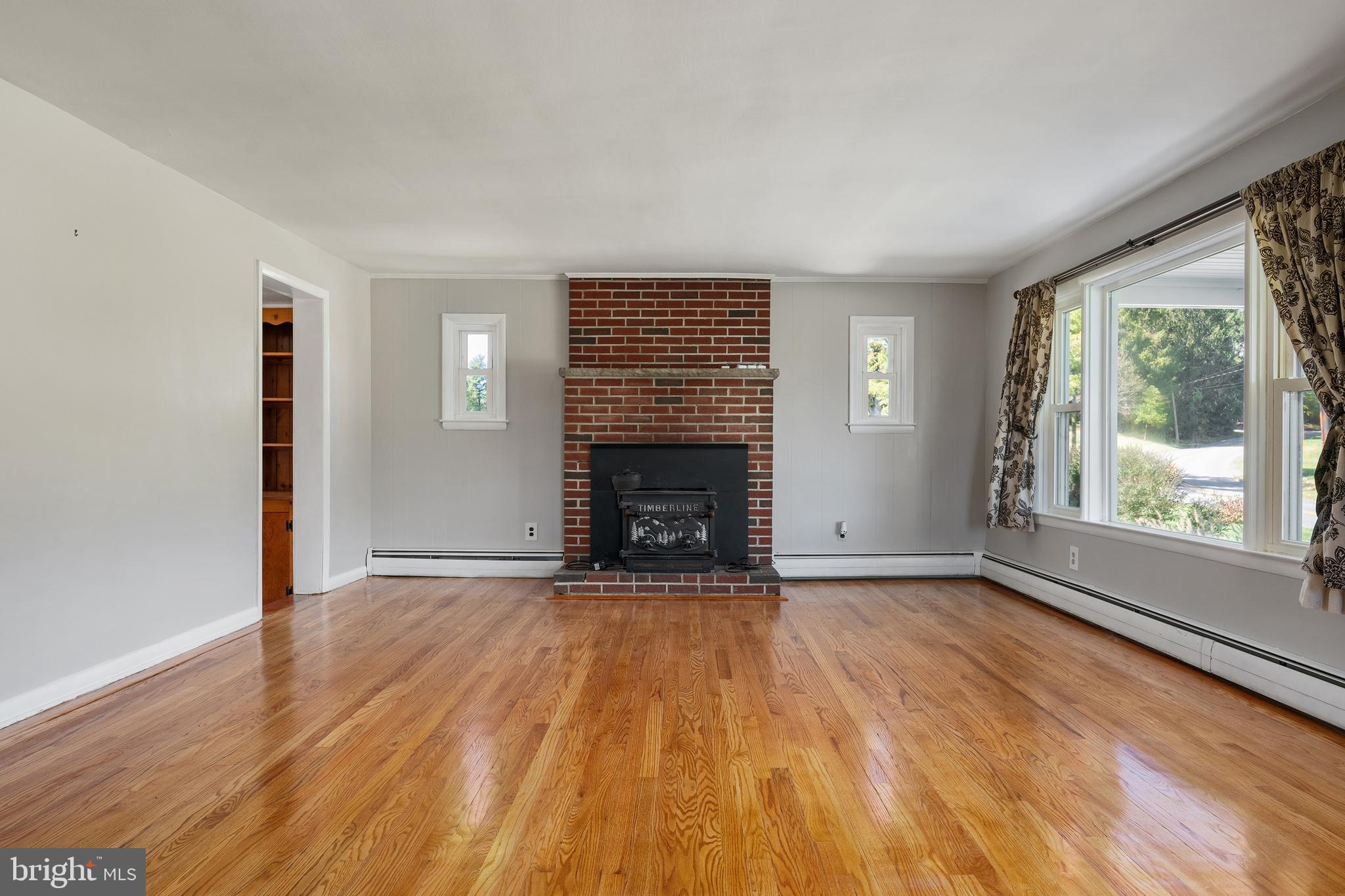 16357 Trenton Road Upperco, MD 21155 - Photo 18 of 68 wooden floor fireplace and windows in an empty room