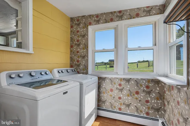 a view of empty room with window and wooden floor